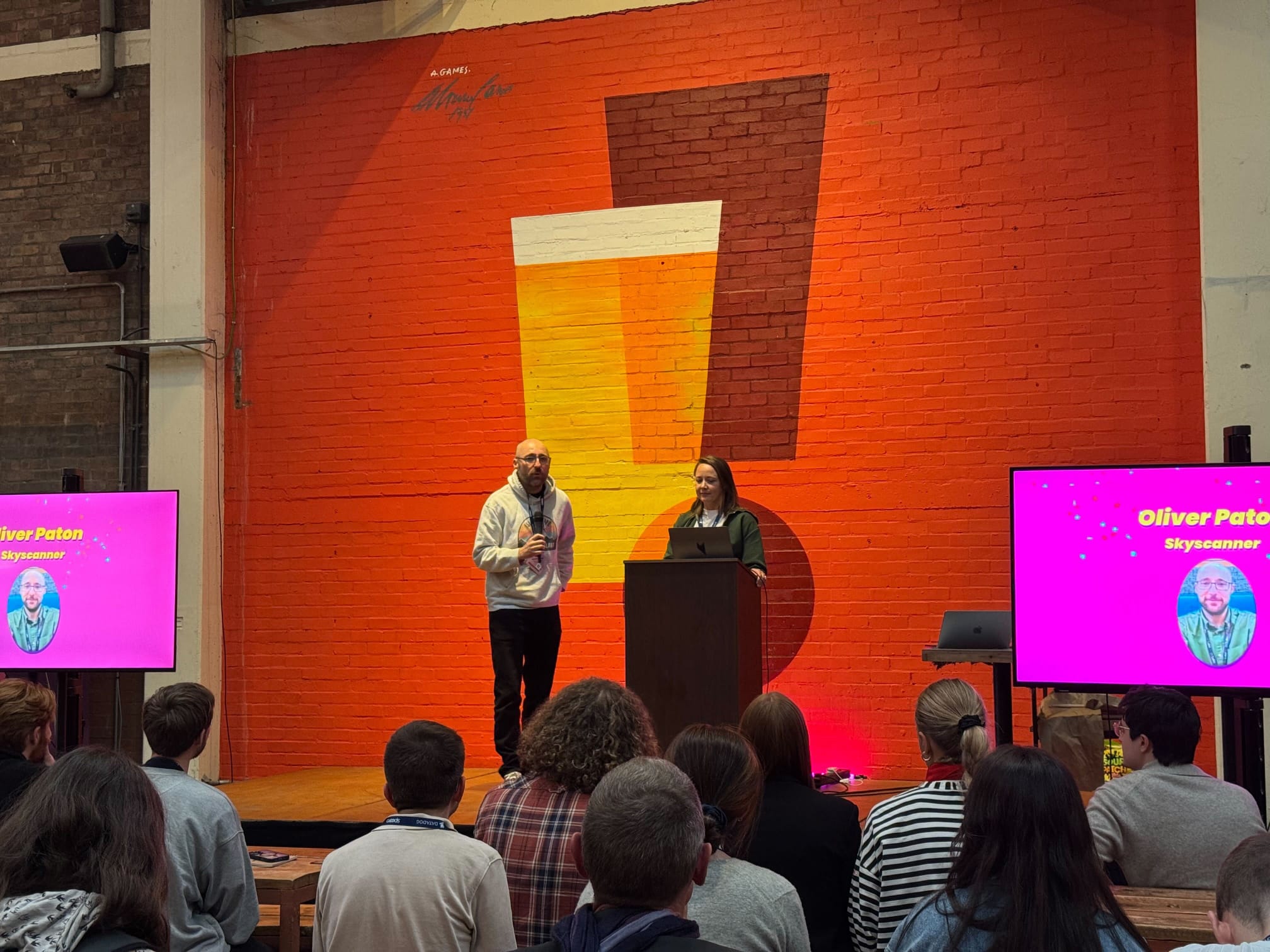 Olly Paton speaking on stage at a conference
